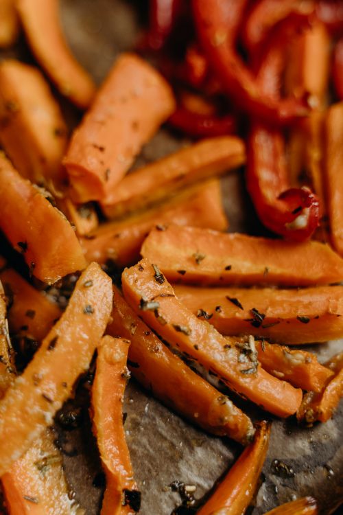 Free Close-up of seasoned roasted carrots and bell peppers, a healthy and vibrant vegan dish. Stock Photo