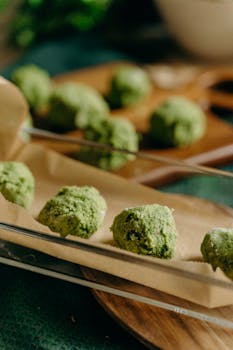 Close-up of freshly prepared green vegetal balls on parchment, perfect for a vegetarian meal.