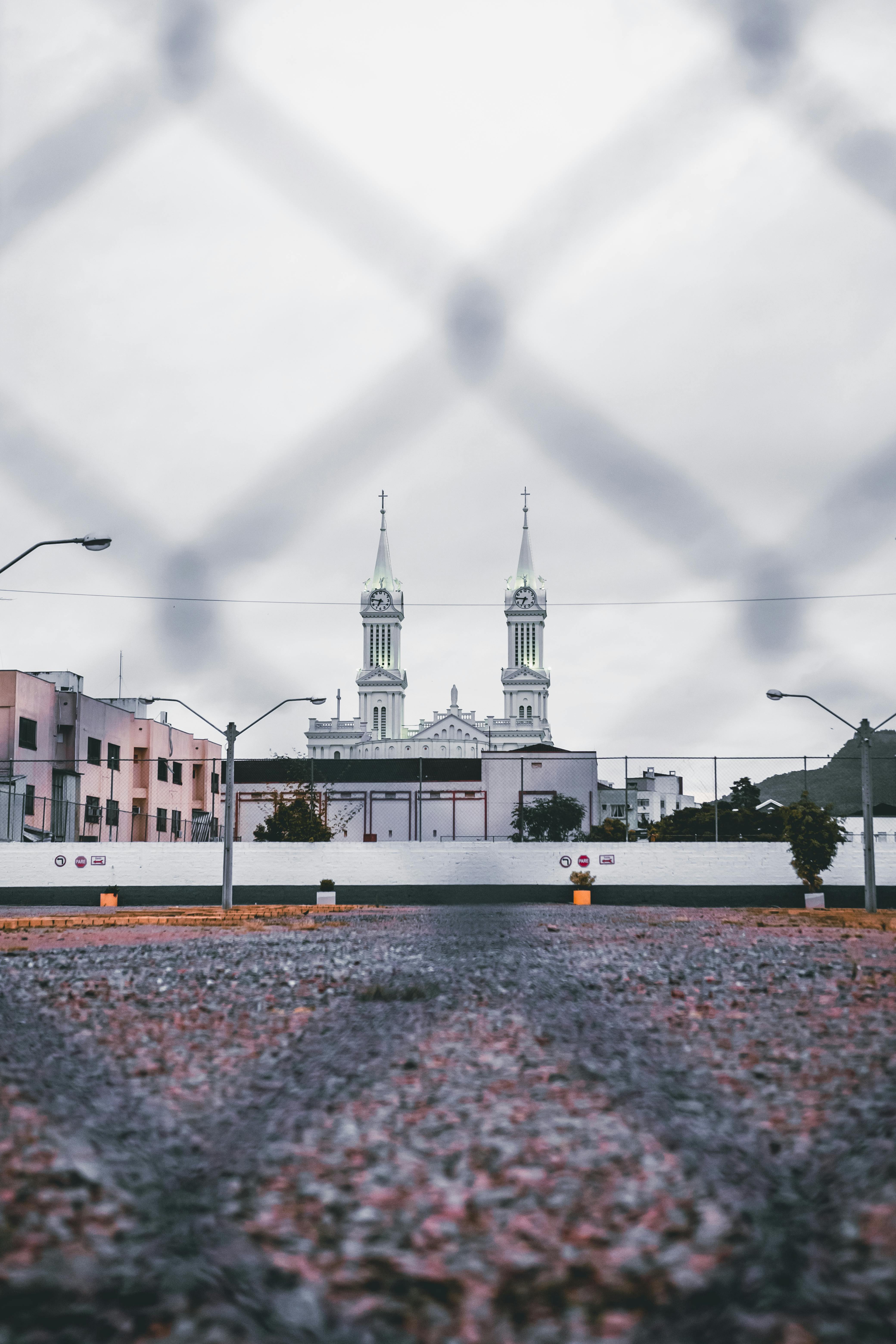 majestic cathedral through wire fence on cloudy day