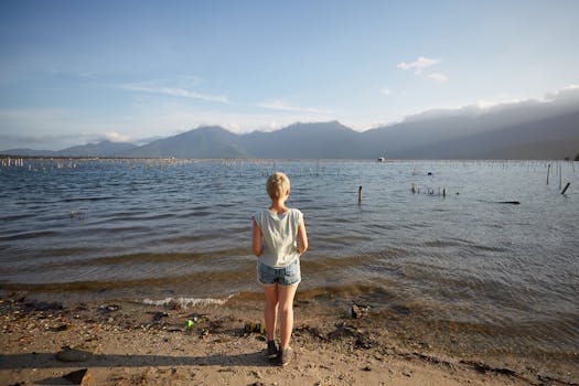 A woman stands by the seashore, gazing at the scenic horizon in Vietnam during summer.