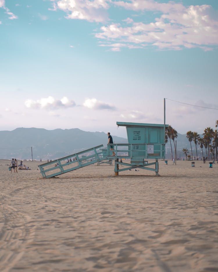 A Man In Black Shirt Standing On A Lifeguard Post 