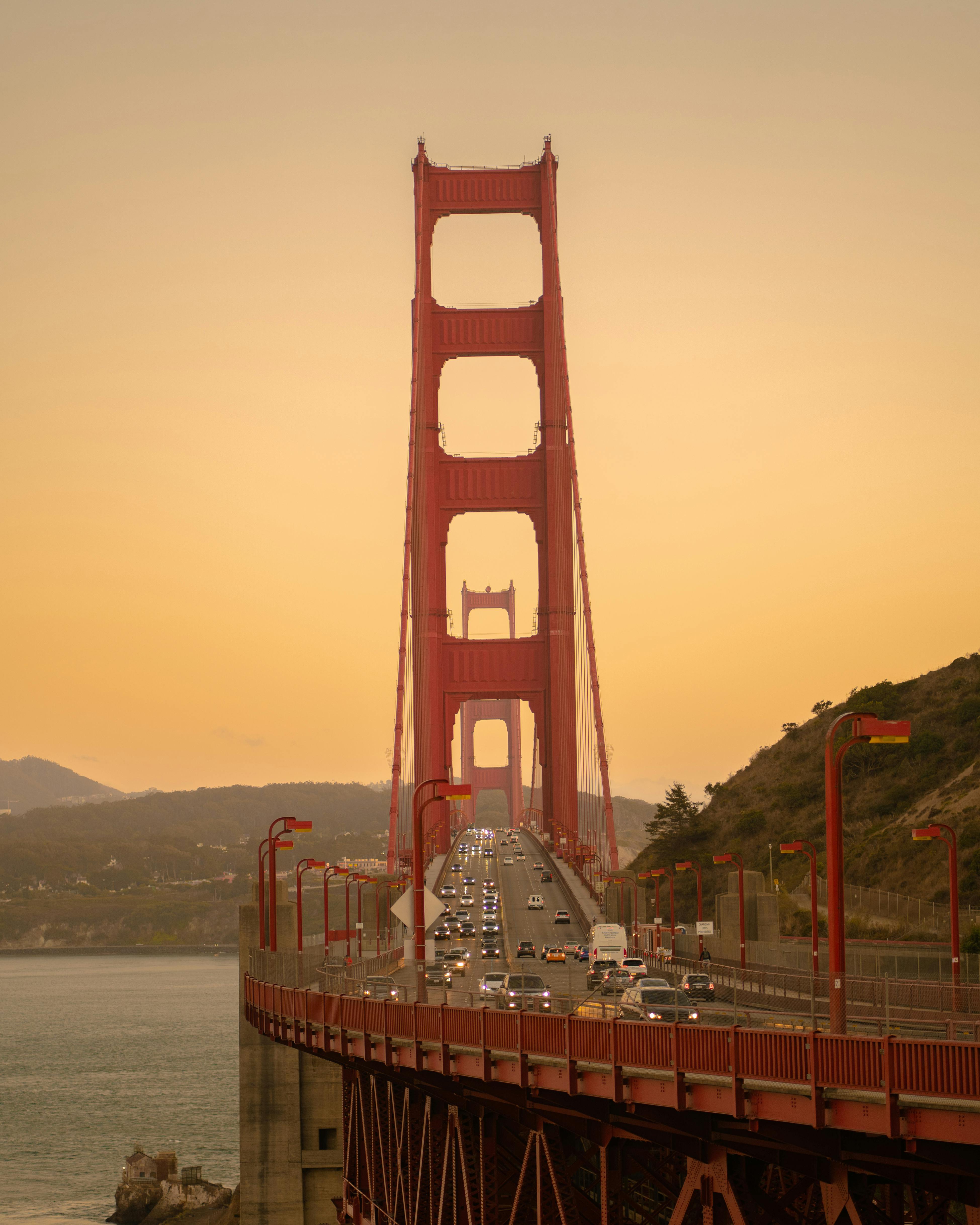 Iconic Golden Gate Bridge during sunset with traffic in San Francisco, showcasing a classic landmark view.