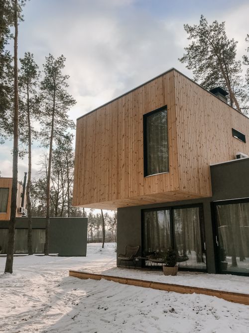 Free Contemporary wooden house surrounded by snowy landscape in a Scandinavian style. Stock Photo