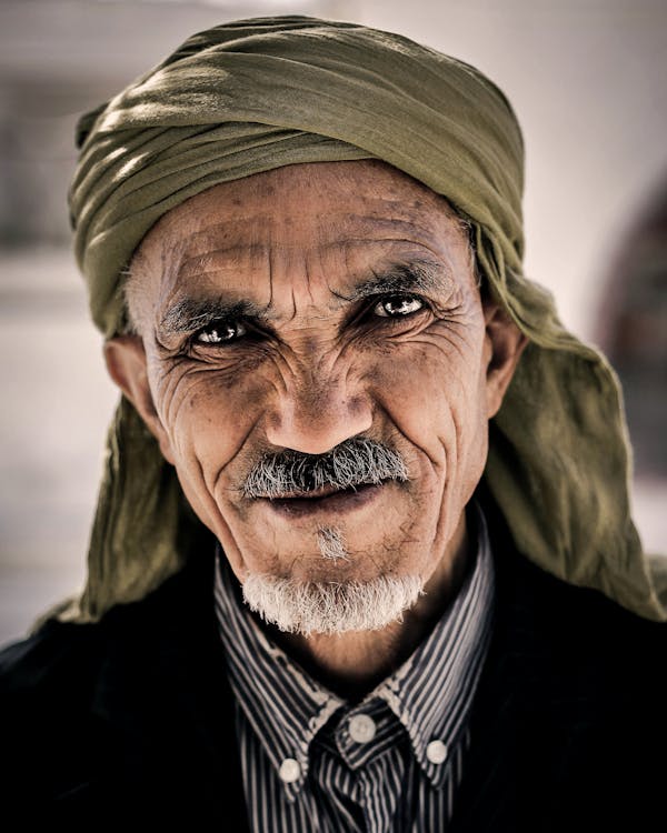 Portrait of Smiling Elder Man Wearing Headscarf