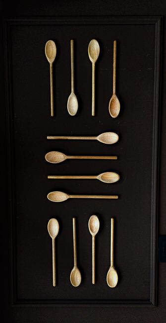 Fotomural Arreglo creativo de cucharas de madera sobre una superficie negra destacando patrones y fotografía de naturaleza muerta.