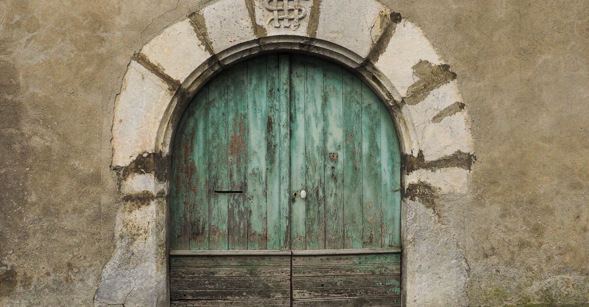 Rustic old wooden door set in stone archway, numbered 64. Perfect for architecture and history themes.