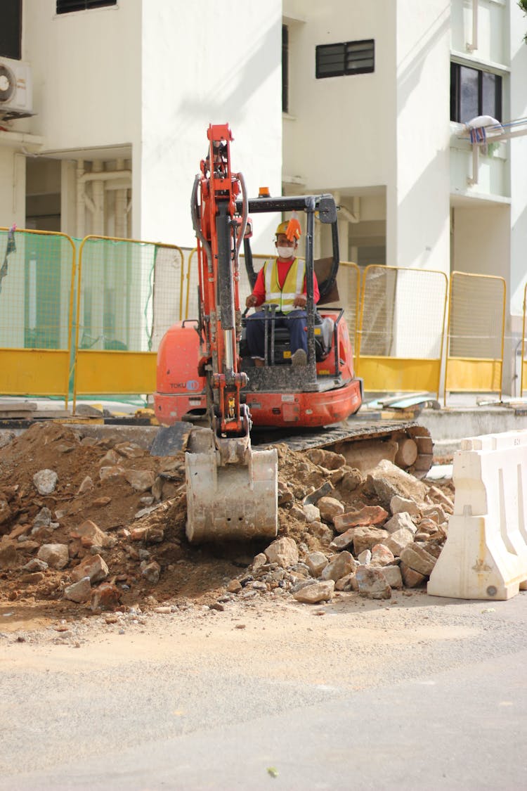 A Person Operating A Backhoe