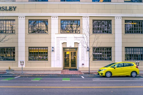 Yellow car parked near entrance of contemporary building