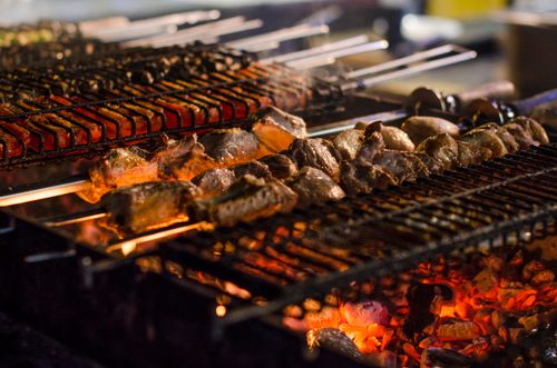 Free Juicy kebabs grilling over open flames on a barbeque. Perfect for summer cookouts. Stock Photo