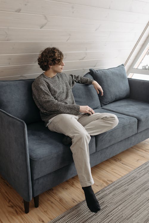 Man in Gray Knitted Sweater resting Comfortably on a Sofa 