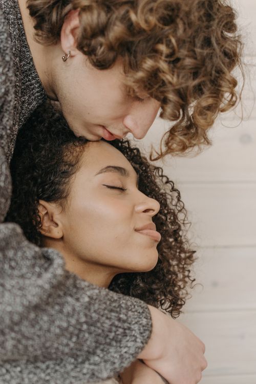 Free A couple sharing a tender embrace, exuding warmth and affection indoors. Stock Photo