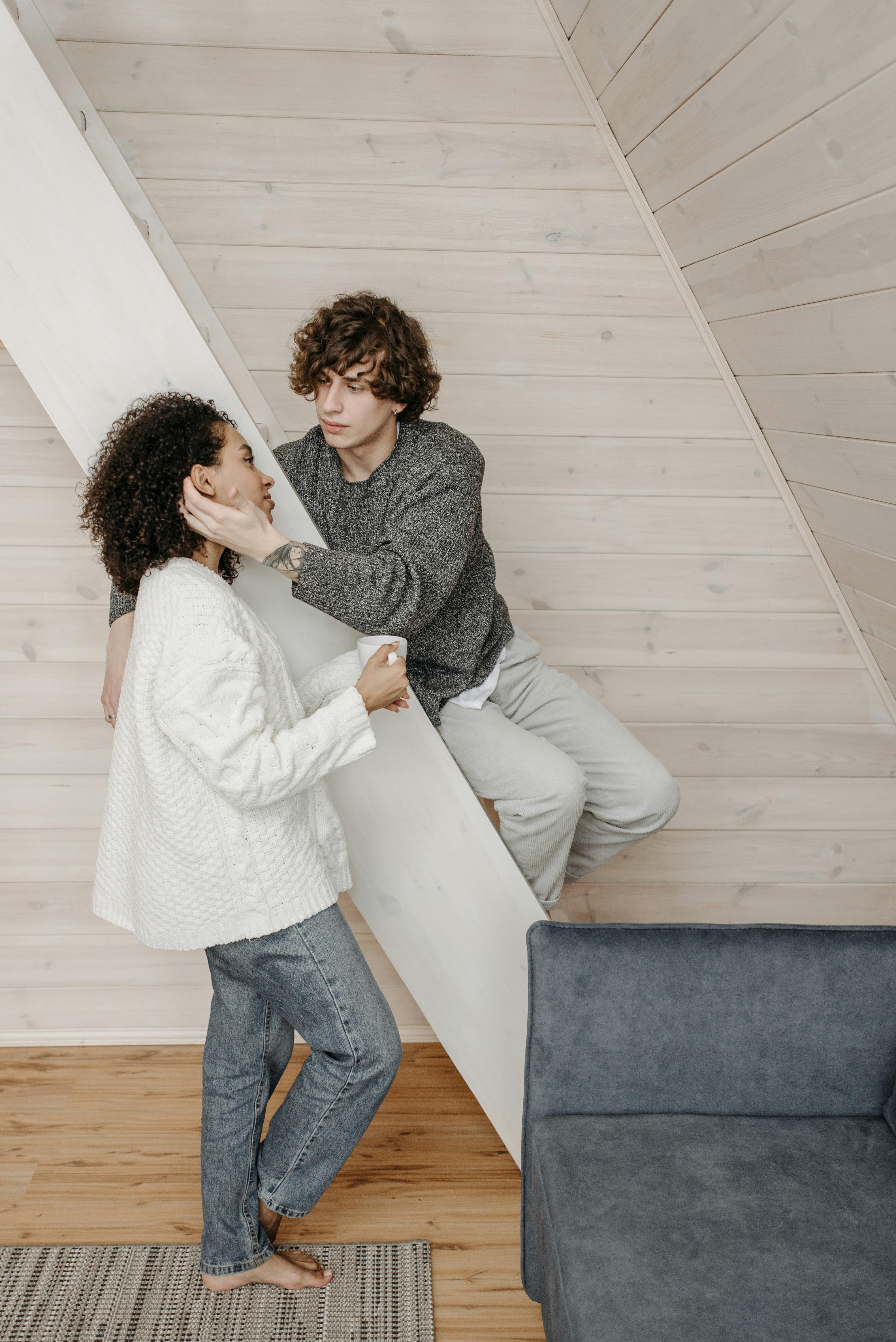 A warm indoor photograph featuring a couple sharing an affectionate moment, highlighting modern lifestyle.
