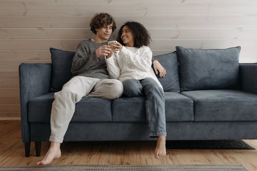 Free A Couple Sitting on a Couch  Stock Photo