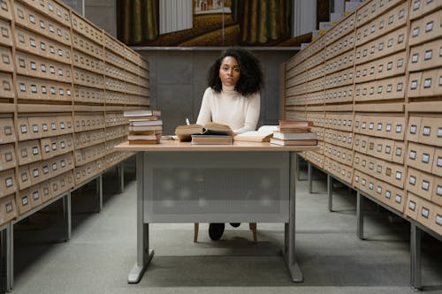 Free Woman studying at a Table with Books Stock Photo