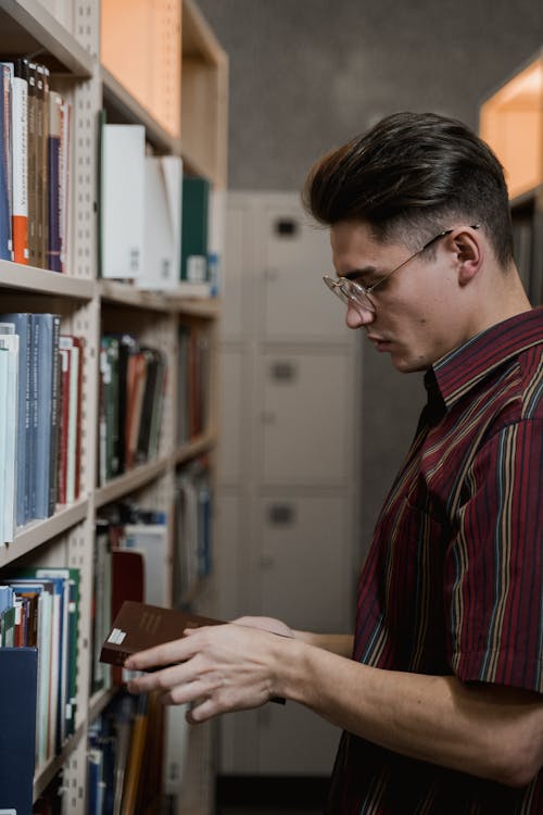 Free A Man in Eyeglasses Holding a Book Stock Photo