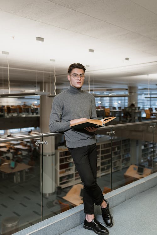 
A Man Wearing a Turtleneck Holding a Book