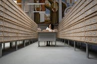 A Woman Sitting at a Desk in a Library