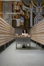 A Woman Sitting at a Desk in a Library