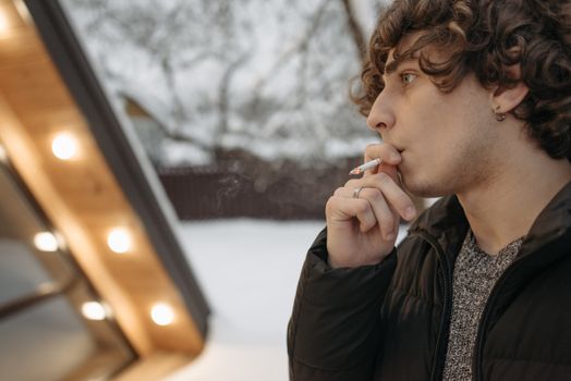 A Man in Black Winter Jacket Smoking Cigarette