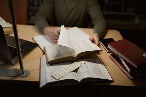 Free A person engrossed in studying with open books on a desk. Stock Photo