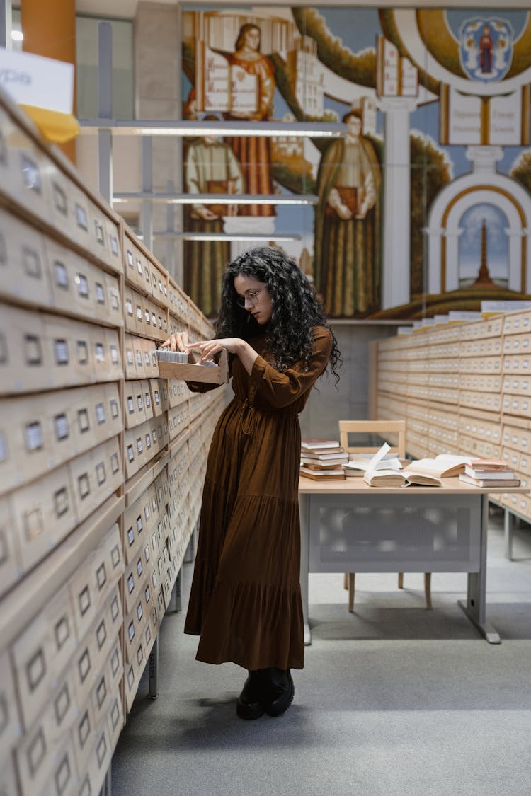 A Woman Searching Through The Library Catalogs