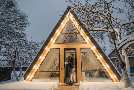 A Couple Standing in Front of a Triangular House