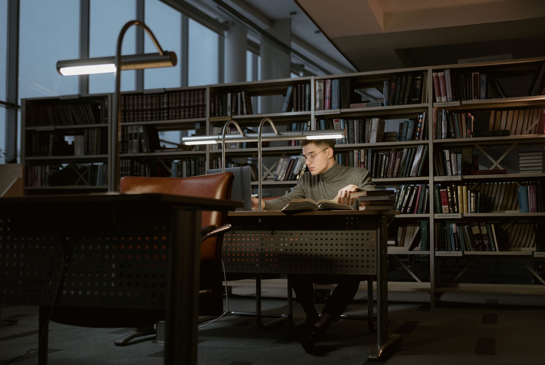 college football analyst studying conference standings and injury reports beside a glowing laptop at midnight
