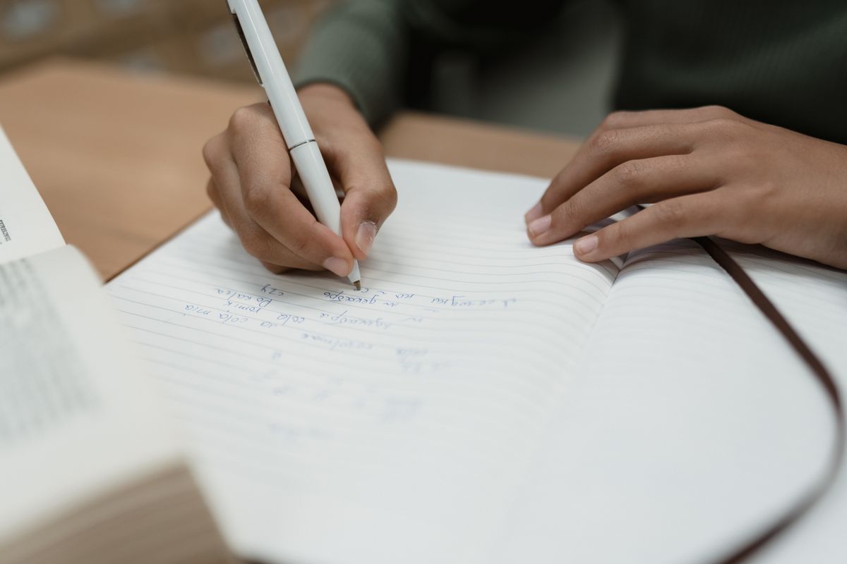 A close-up of a hand writing in a notebook