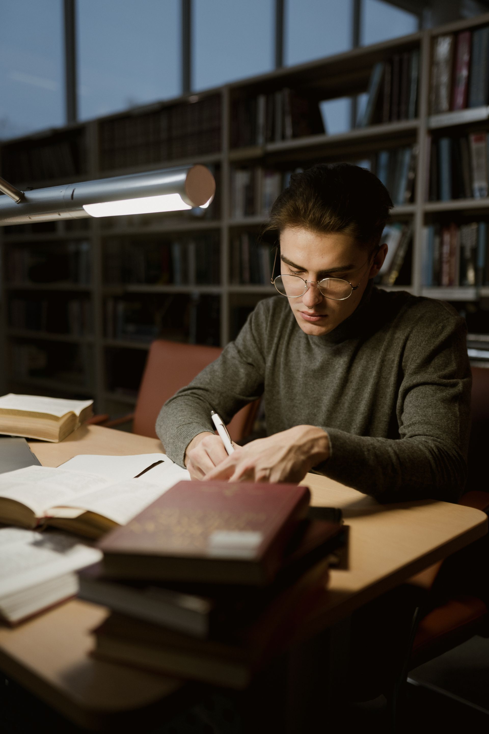 Hombre que estudia solo en un pasillo de una biblioteca