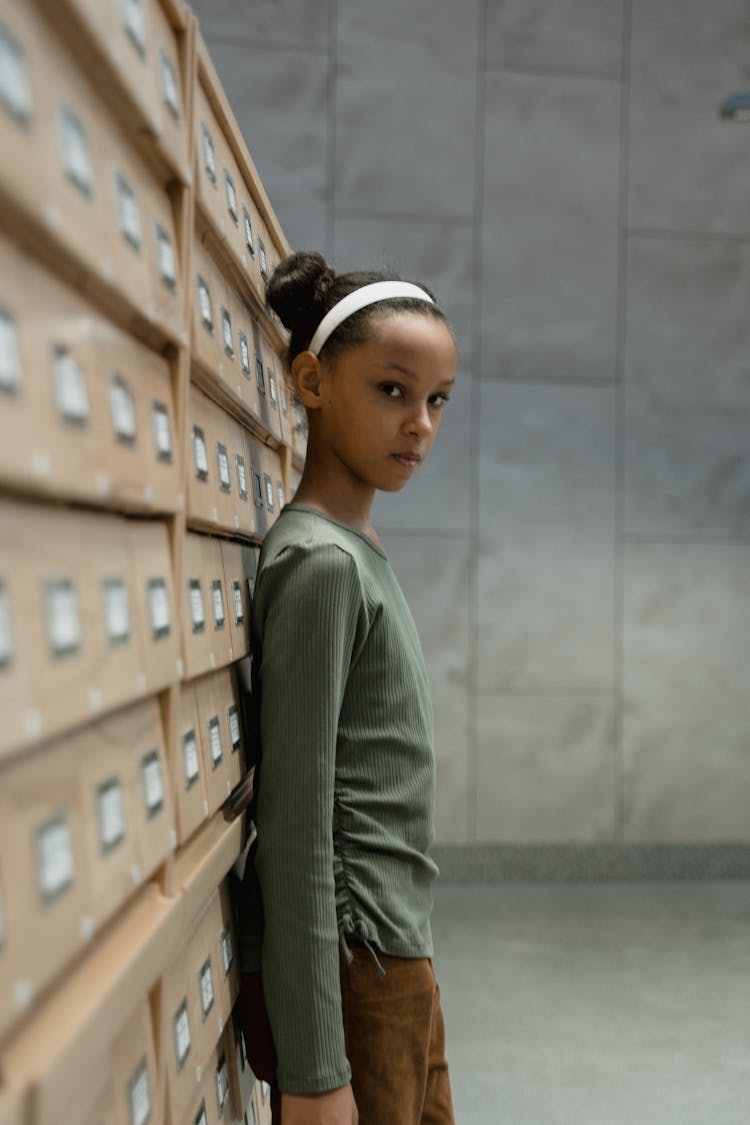 A Woman Leaning On Wooden Database Drawer While Looking At The Camera