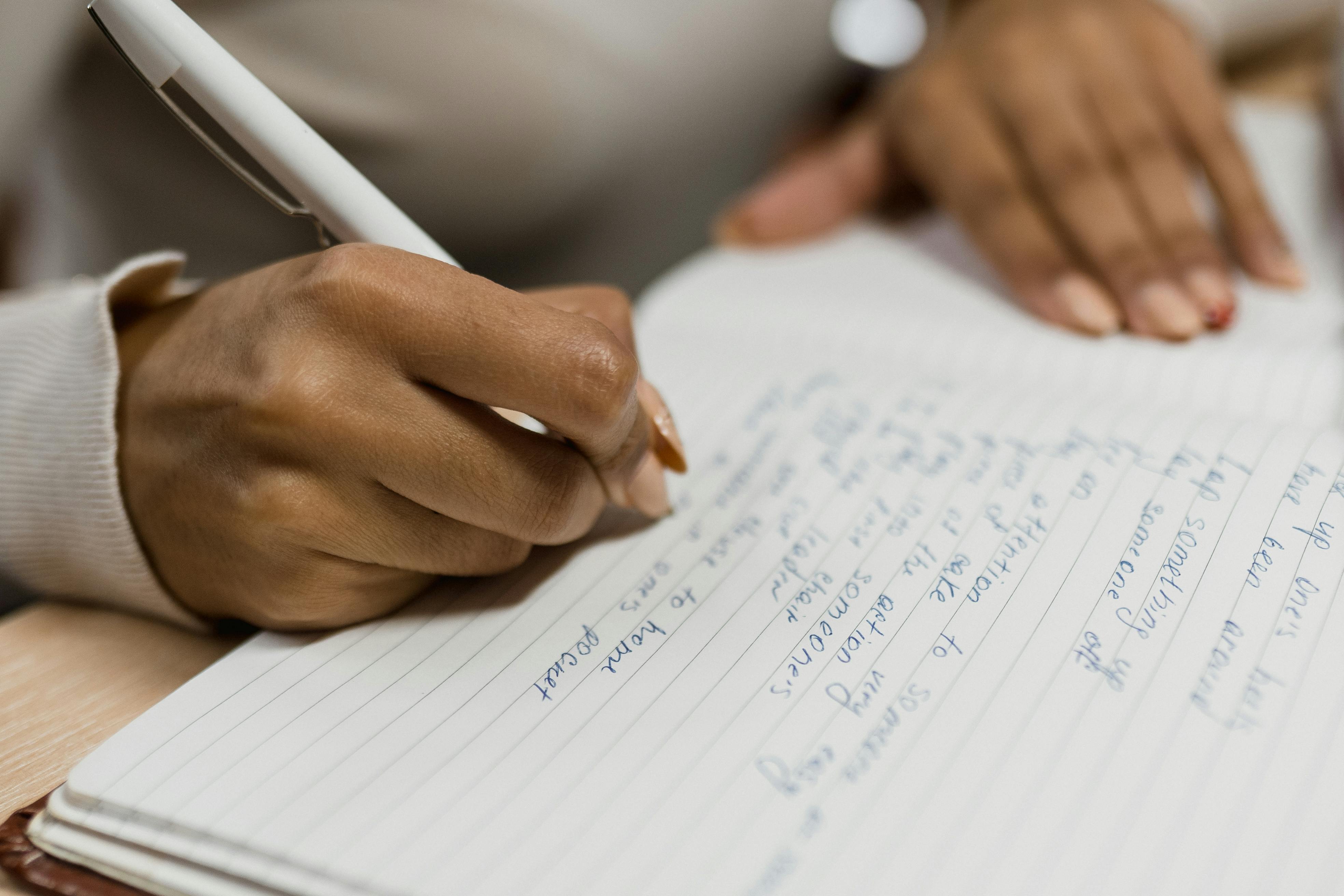 A Person Writing On A Notebook · Free Stock Photo