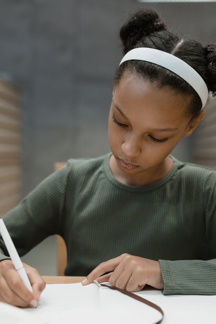 Close-up Photo Of A Student Writing On A Paper 