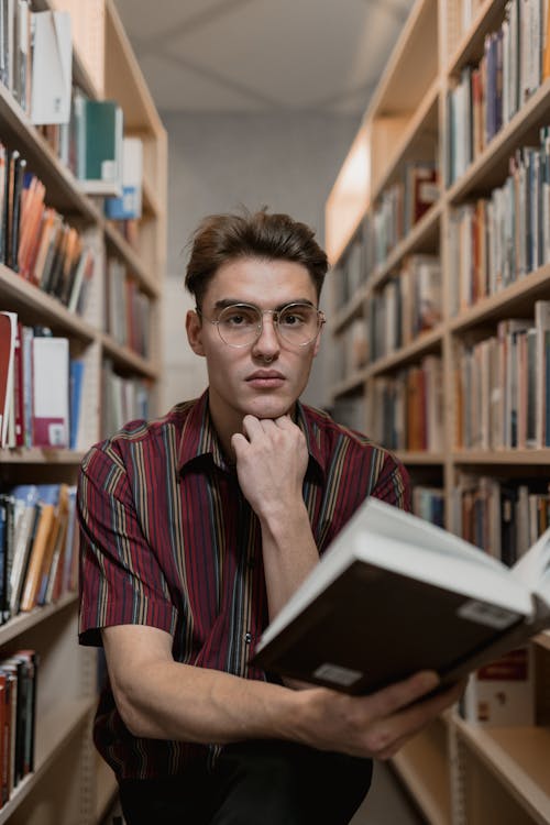 Man in Button Up Shirt Holding a Book