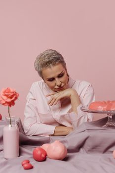 Serene woman in pink setting with roses and pastel elements creating a calming aesthetic vibe.