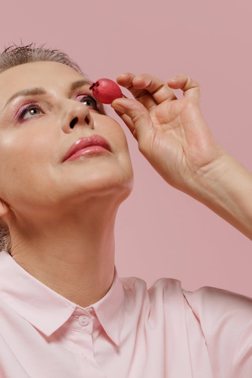 Free Woman in a Pink Long Sleeves Holding a Pink Fruit Stock Photo