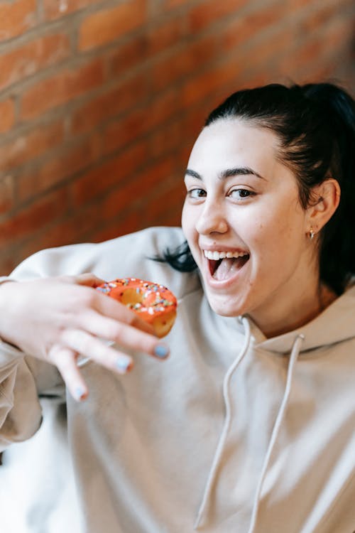 Happy young woman eating sweet donut