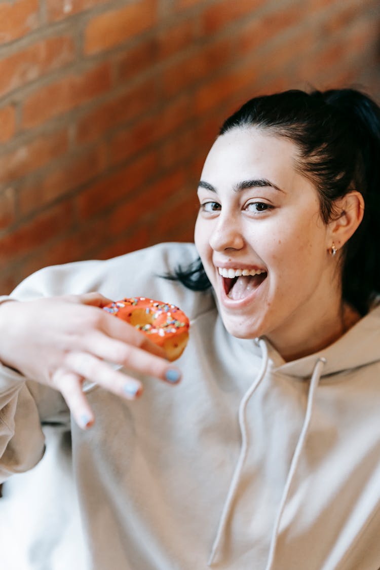 Happy Young Woman Eating Sweet Donut