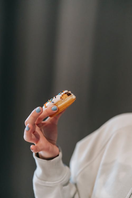 Crop anonymous woman demonstrating delicious donut