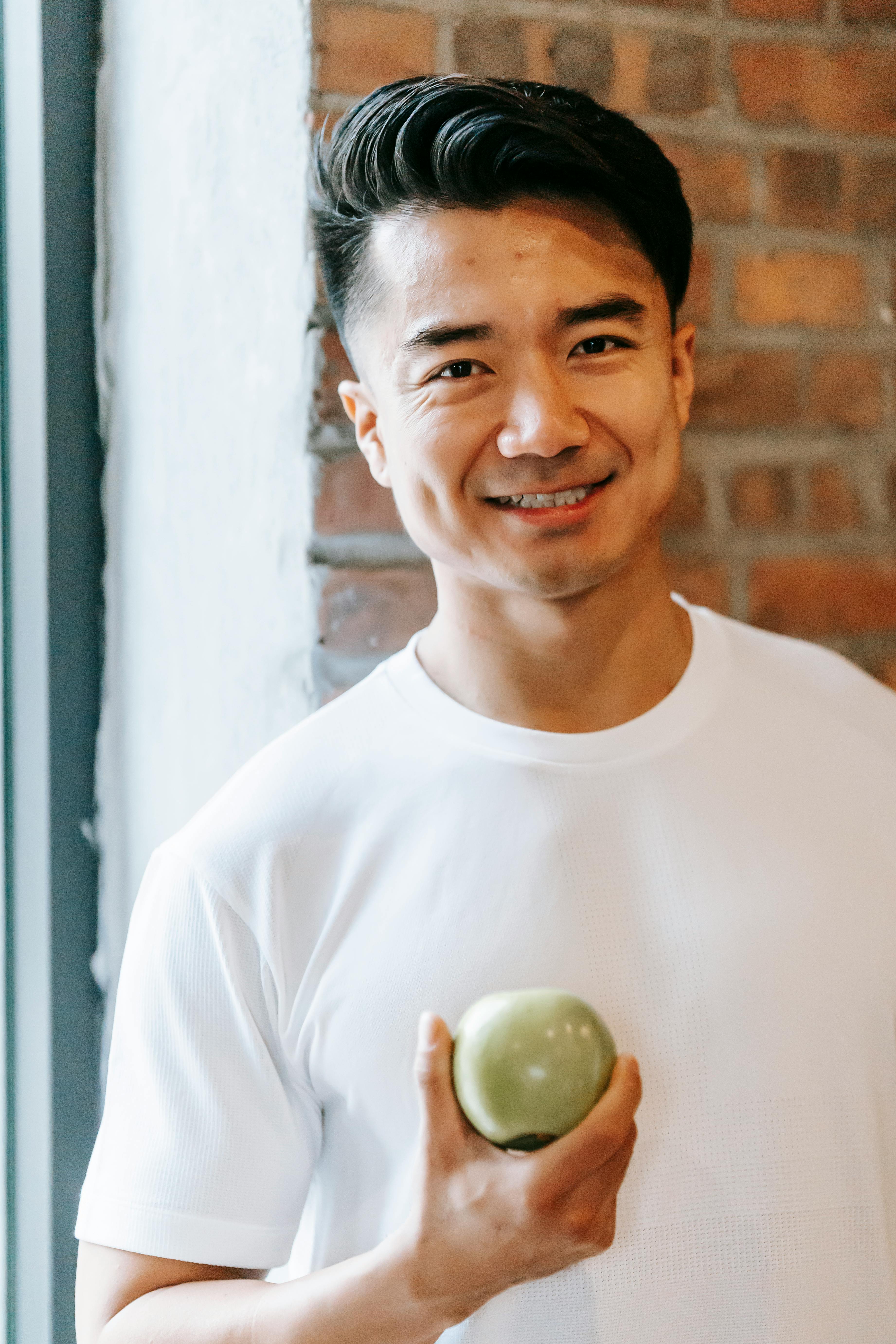 content asian man with green apple