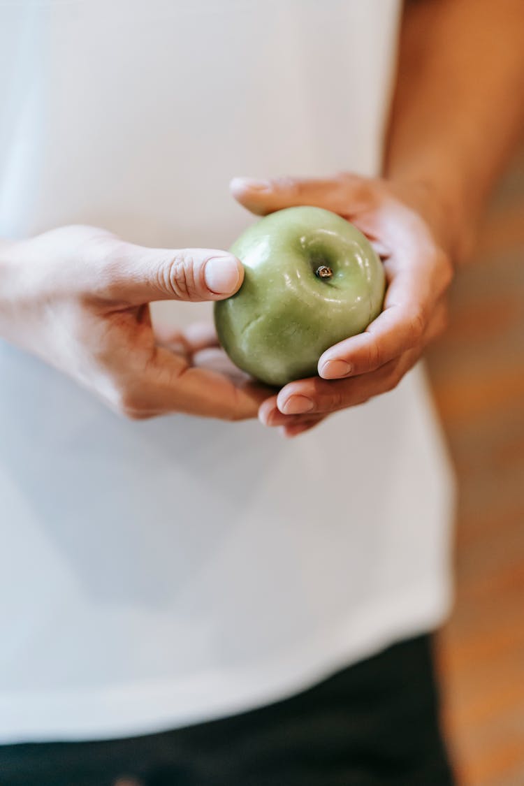 Crop Unrecognizable Person Demonstrating Green Apple