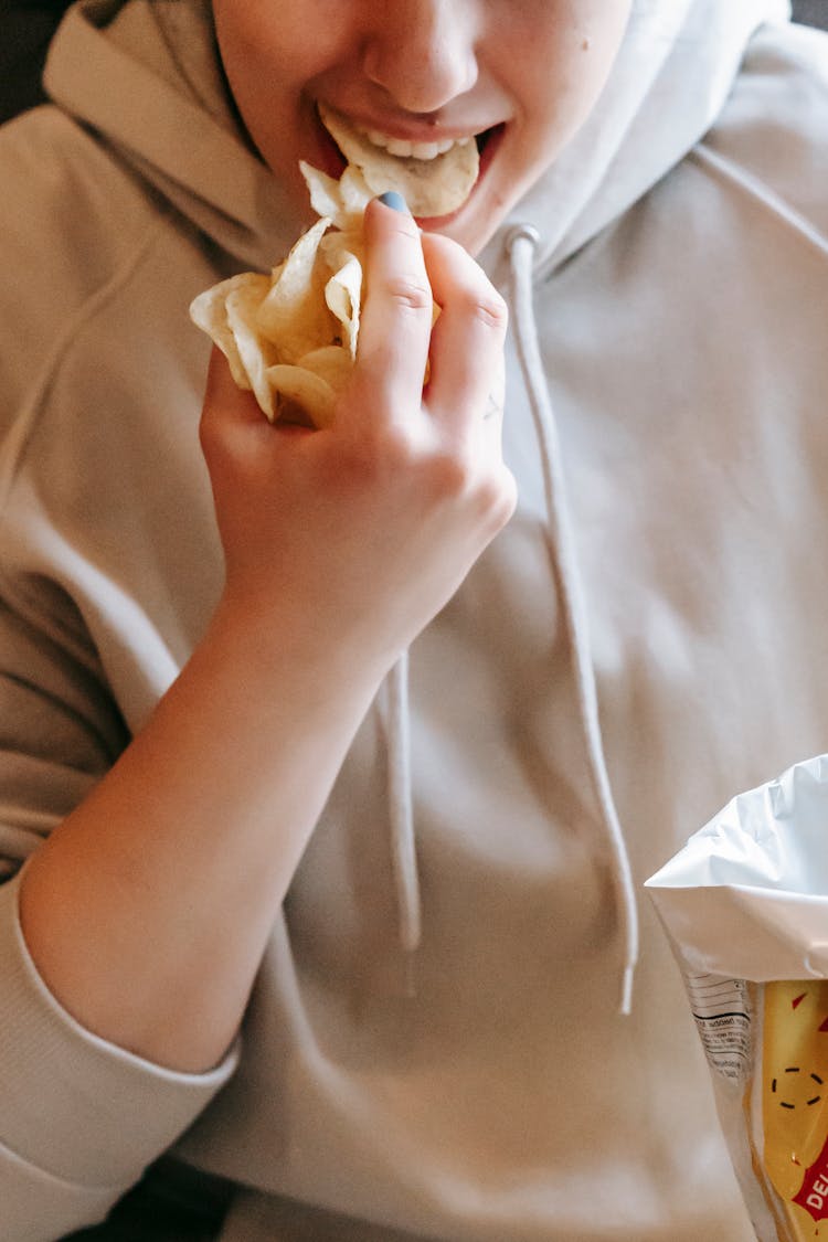 Crop Woman Eating Crispy Chips