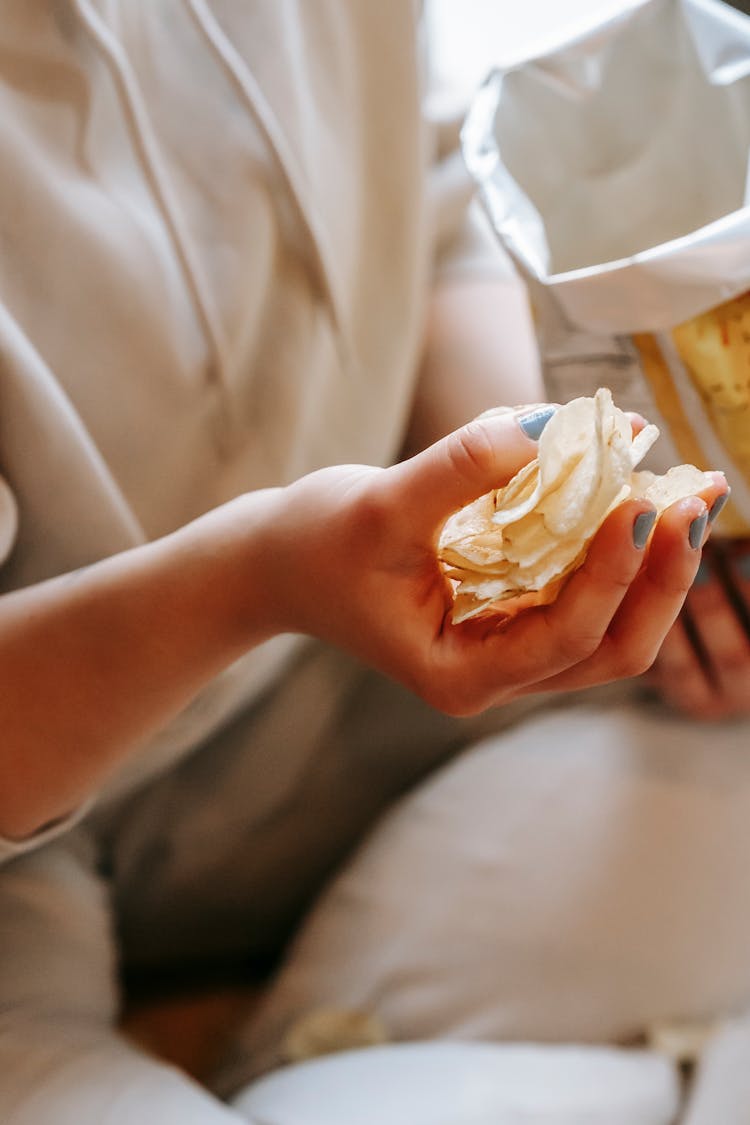 Crop Faceless Woman Eating Crispy Chips