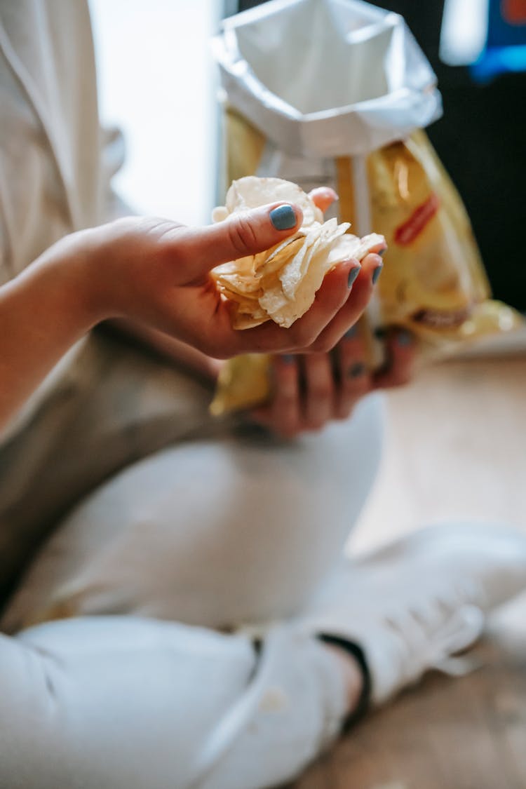 Crop Unrecognizable Plump Woman Eating Yummy Potato Chips