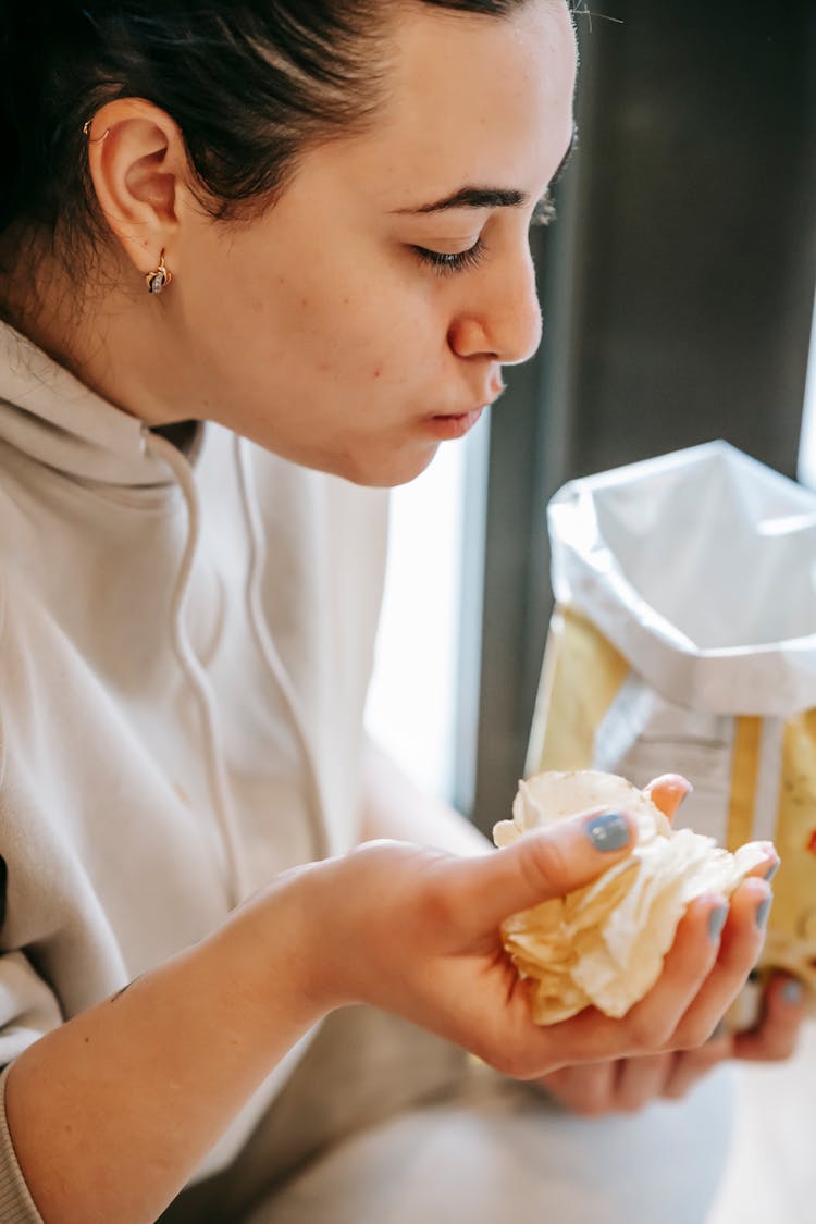 Young Woman Eating Tasty Potato Chips In Daylight