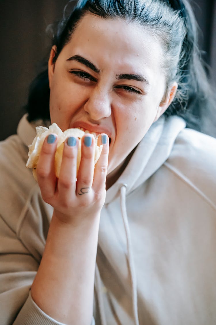 Ethnic Woman Devouring Unhealthy Chips