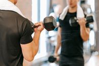 Crop man working out with weights in gym