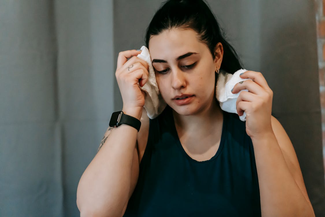 Free Tired plump ethnic woman in gym with towel Stock Photo