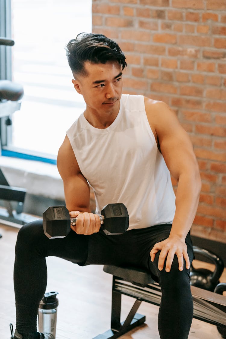 Strong Asian Man Training Biceps In Gym