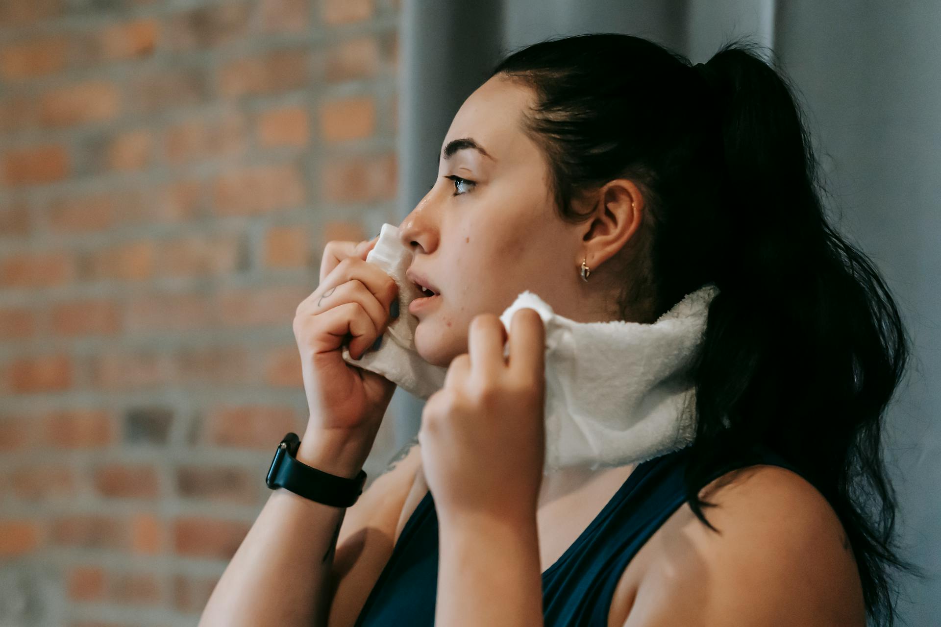 Ethnic woman with towel exercising in gym