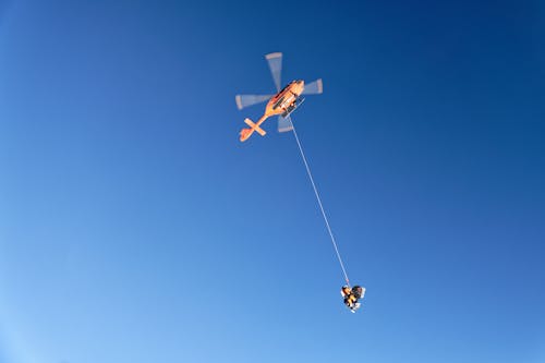 Free Helicopter with Rescuer in Sky Stock Photo